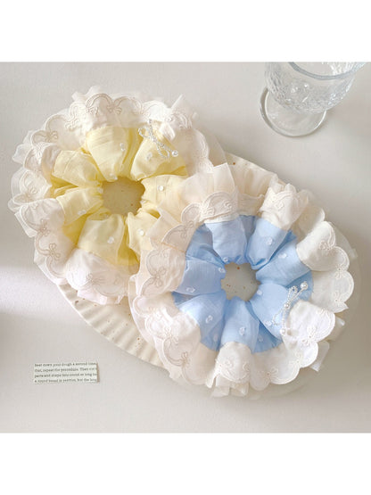 Close-up of Gifty elegant minimalist polka dot scrunchie in white with black dots