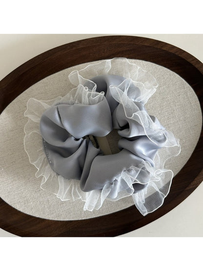 Gifty vintage tulle ruffle scrunchie displayed in natural light on a wooden surface