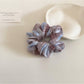 Close-up of Gifty scrunchie elastic band inside checkered fabric