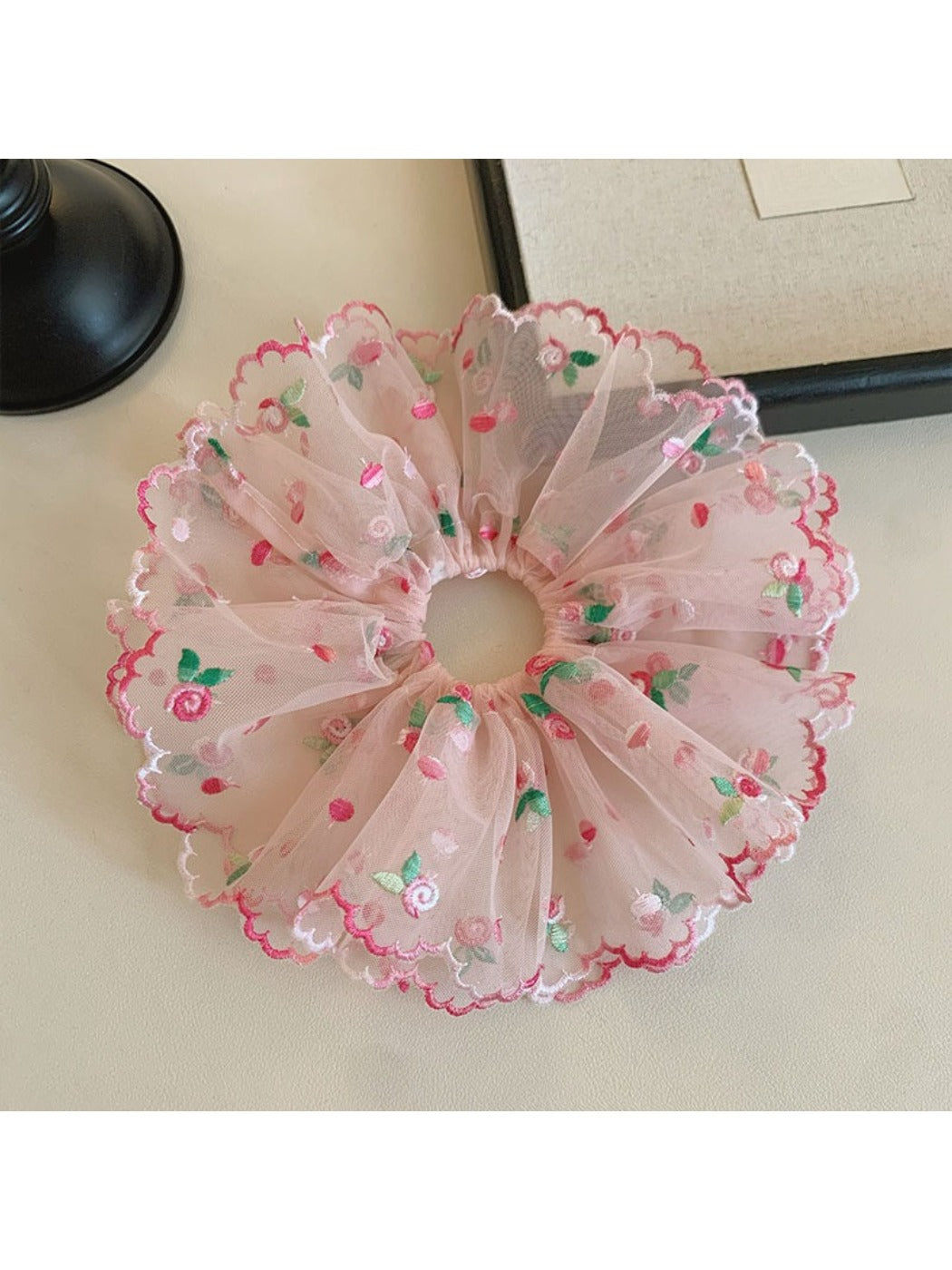 Pink ruffled scrunchie displayed flat showing texture and layers