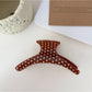 Beau polka dot hair clip held in hand displaying size and shape