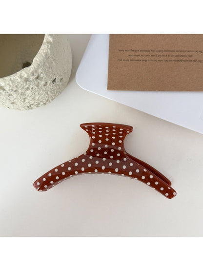Beau polka dot hair clip held in hand displaying size and shape