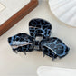 Beau leopard print bow-shaped claw clip angled to show clasp details