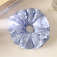 Close-up of Gifty chic floral accented ruched scrunchie in soft fabric