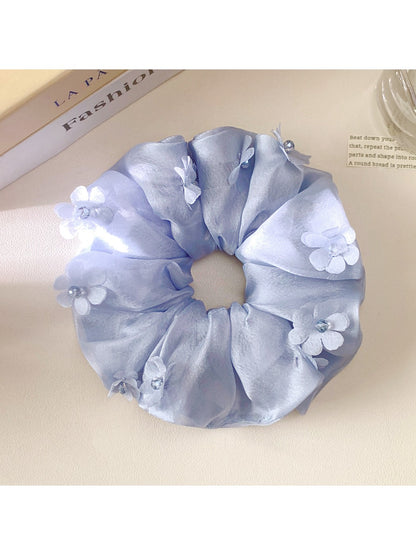 Close-up of Gifty chic floral accented ruched scrunchie in soft fabric