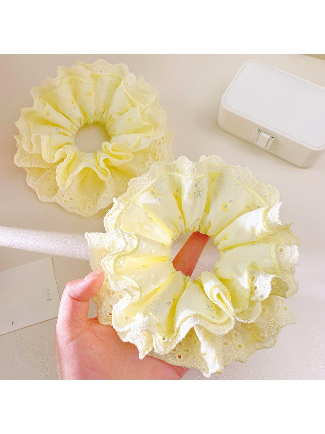 Close-up of Gifty sweet yellow ruffle scrunchie with soft fabric texture