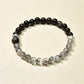 Lovra bracelet styled with other jewelry pieces on a wooden surface