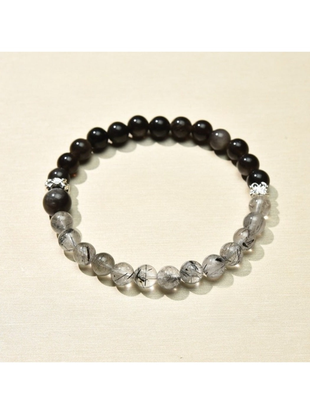 Lovra bracelet styled with other jewelry pieces on a wooden surface