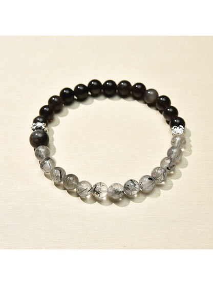 Lovra bracelet styled with other jewelry pieces on a wooden surface