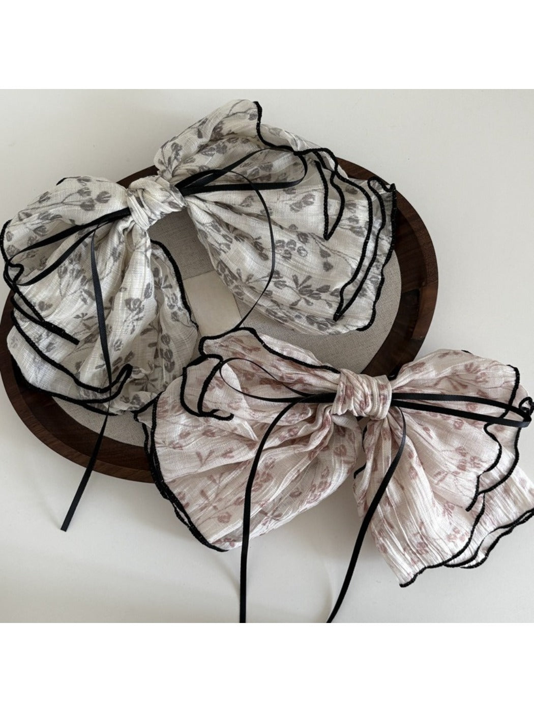 Close-up of Beau floral bow hair clip showing detailed pink and white flower design