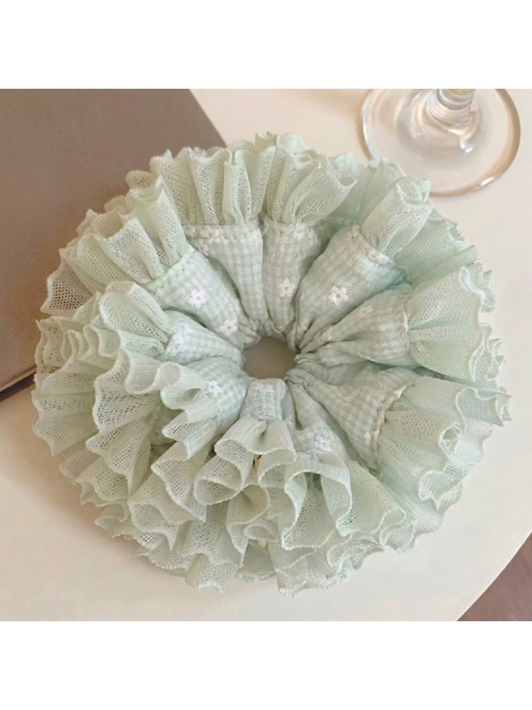 Close-up of mint green plaid tulle fabric and ruffle details on scrunchie