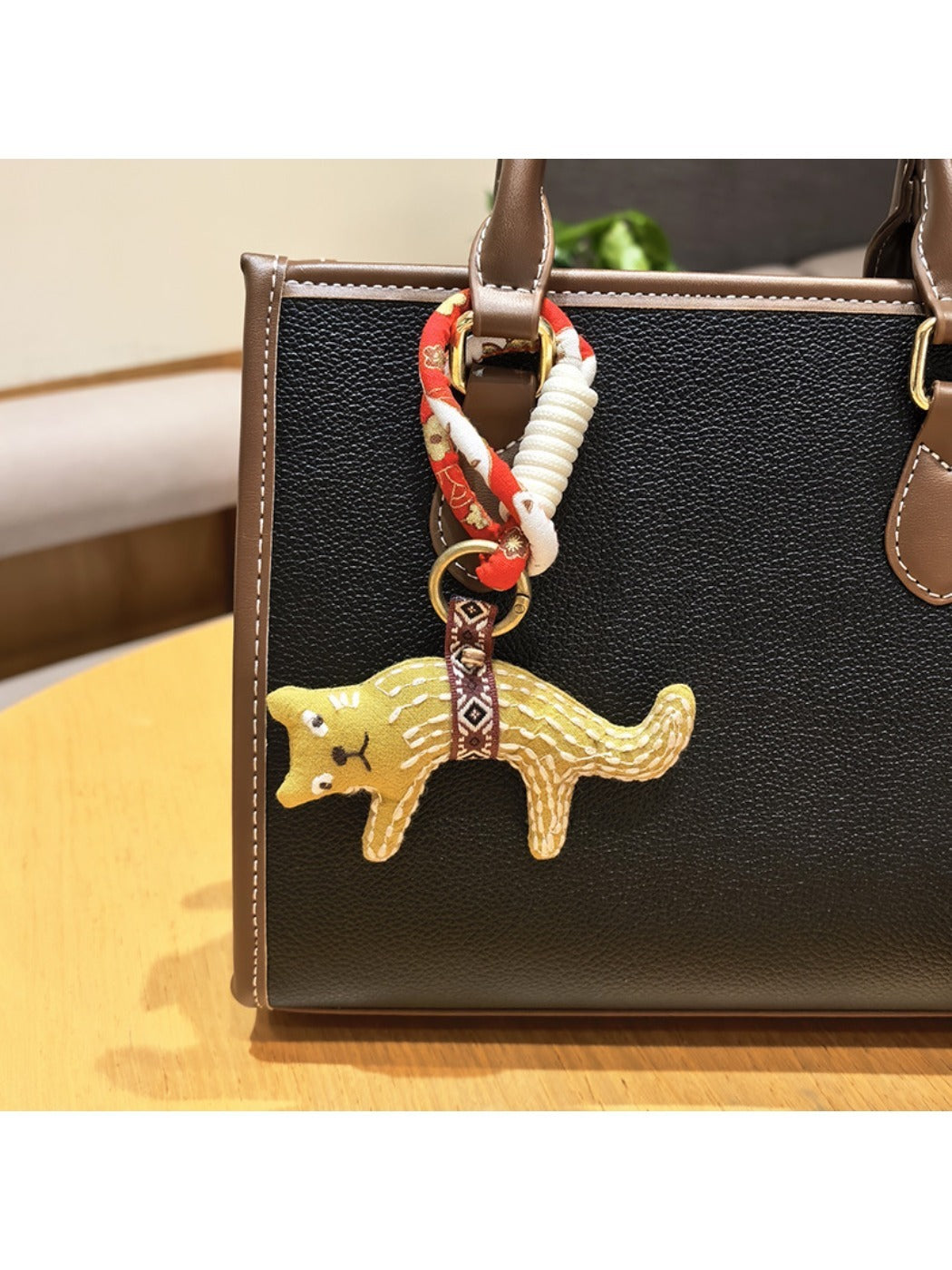 Fox charm keychain hanging on a decorative hook with other keychains