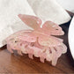 Beau butterfly hair claw clip worn in half-up hairstyle on model with dark hair