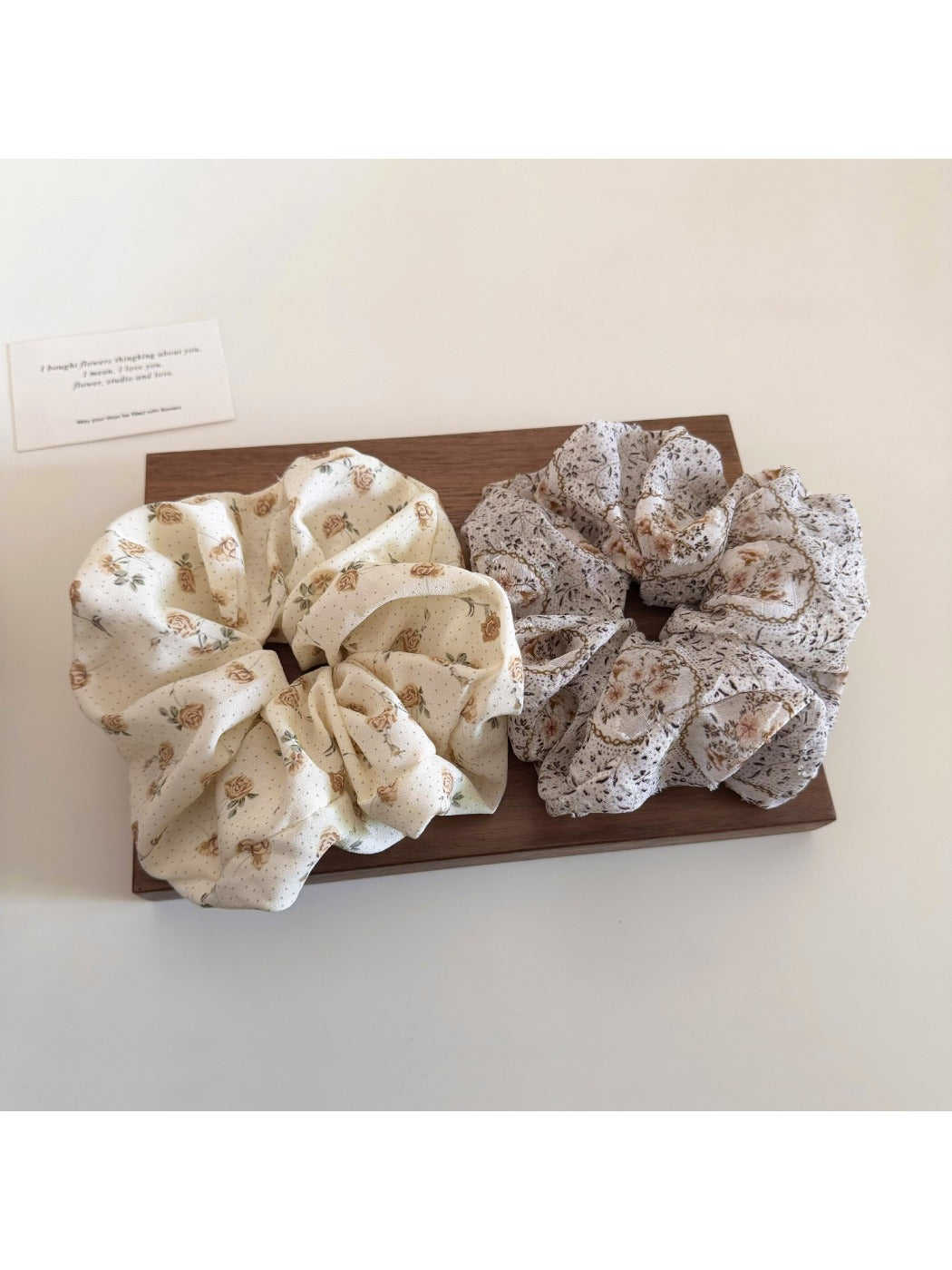 Flat lay of Gifty floral print scrunchie on white background highlighting fabric details