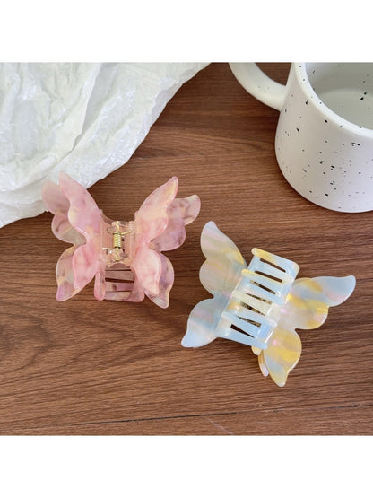 Close-up of pastel pink butterfly claw clip showing detailed wings