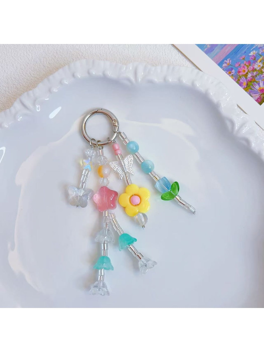 Keypus star and flower charm keychain with gold ring on white background