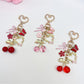 Cherry bow charm keychain with red cherries and a pink bow on a silver keyring