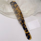 Camerow long handle hair comb resting on a towel in a bathroom setting