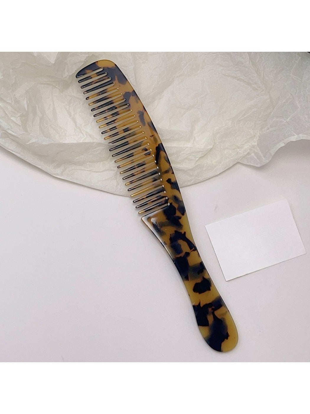Camerow long handle hair comb resting on a towel in a bathroom setting