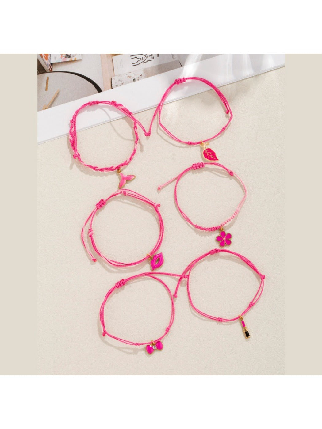Lovra bracelet with lipstick bow-shaped pendant on woven band