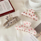 Close-up of Beau hair claw clip showing curved half moon shape and vibrant print