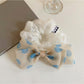 Gifty hair tie with black polka dot bow displayed on a white background
