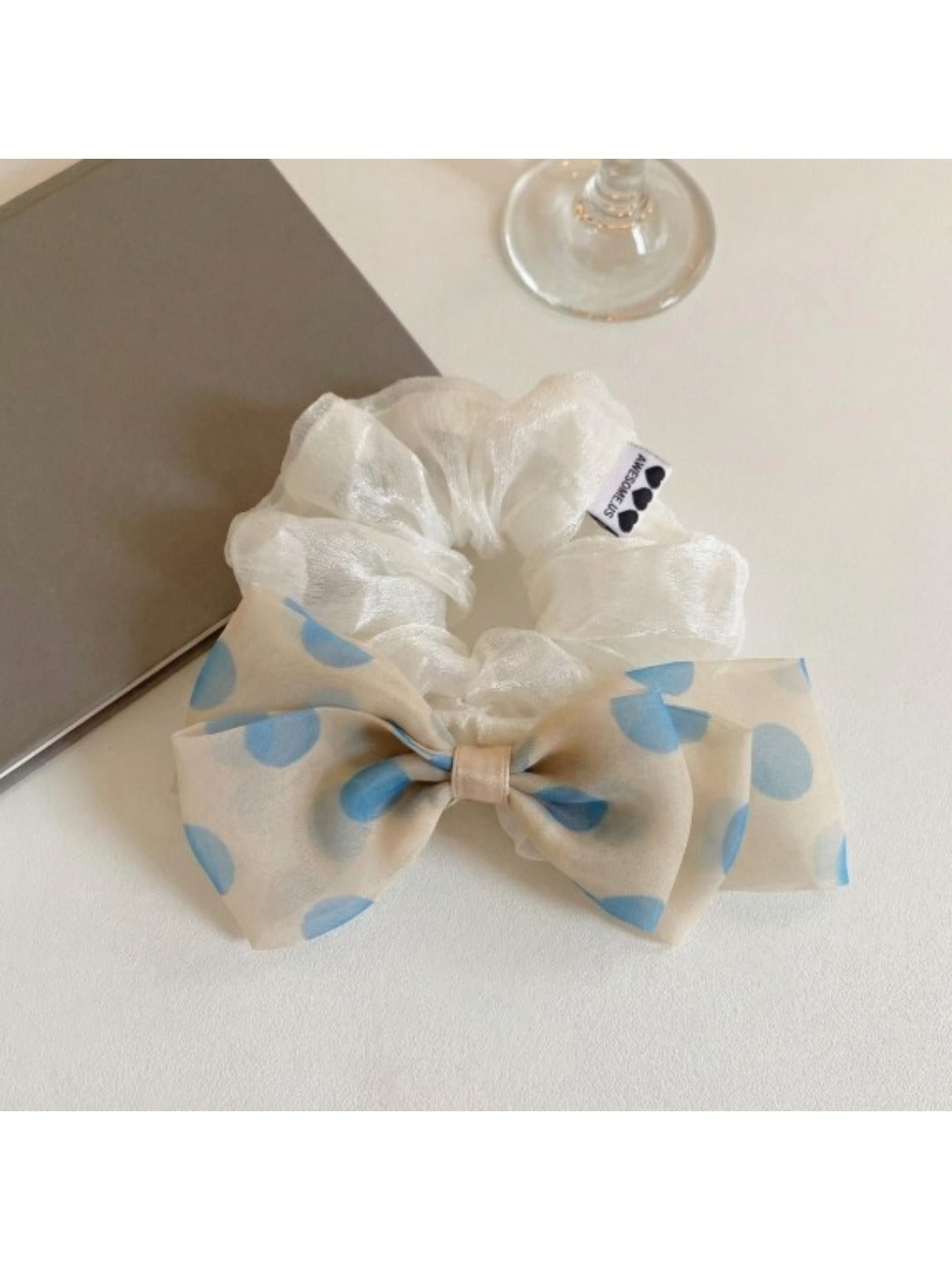 Gifty hair tie with black polka dot bow displayed on a white background