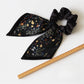 Gifty printed bow hair tie laid flat highlighting bow shape and elastic band