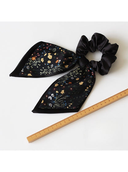 Gifty printed bow hair tie laid flat highlighting bow shape and elastic band