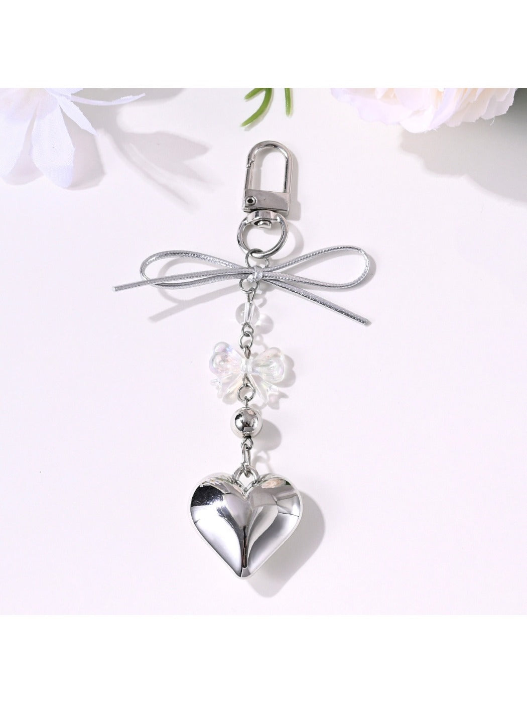 Keypus bow keychain held in hand highlighting star and heart design