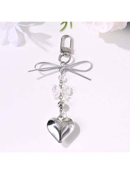 Keypus bow keychain held in hand highlighting star and heart design