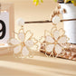 Earedge flower shaped drop earrings hanging from a jewelry stand