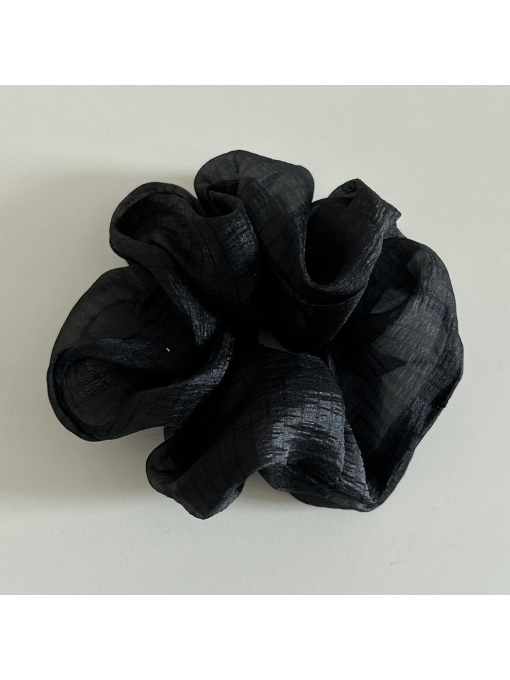 Side view of minimalist beige tulle scrunchie showing gathered fabric