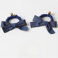 Top view of vintage bow hair tie highlighting bow shape and fabric texture