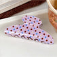 Beau pink polka dot claw clip open to show inner clasp and teeth details