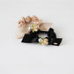 Close-up of Gifty chic floral embellished hair tie with pink and white fabric flowers