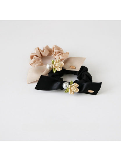 Close-up of Gifty chic floral embellished hair tie with pink and white fabric flowers