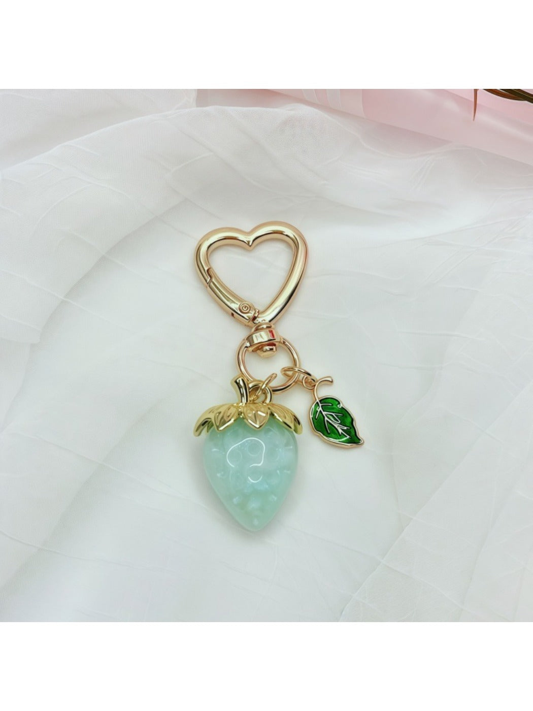 Keypus strawberry charm keychain photographed with soft natural lighting