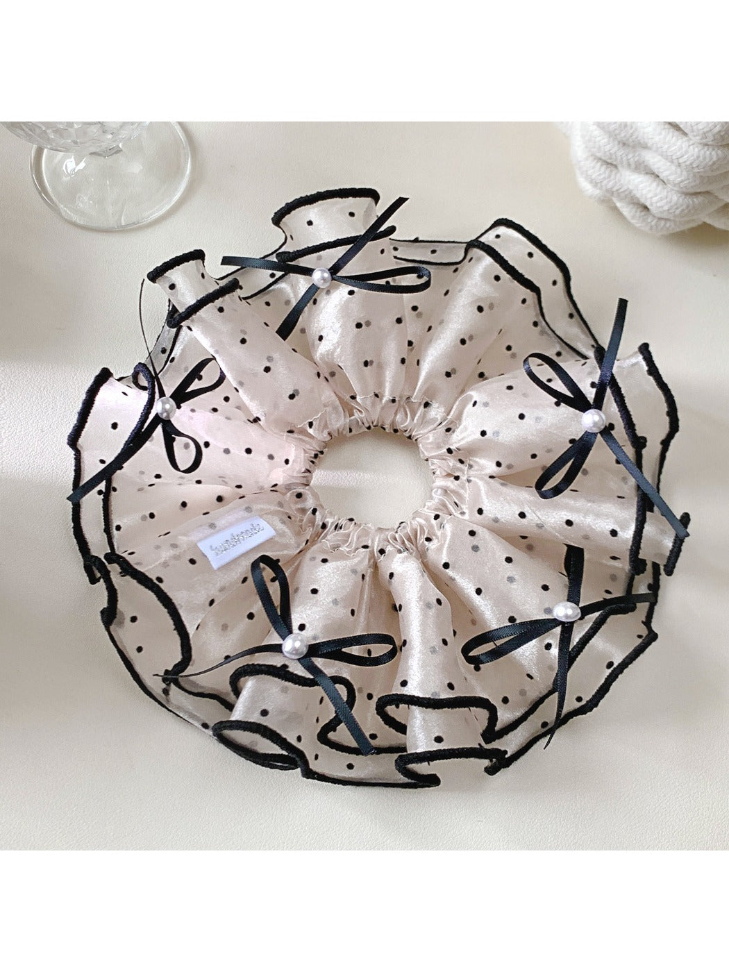 Gifty satin polka dot bow scrunchie worn on a model's wrist