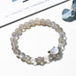 Close-up of Lovra minimalist gray crystal beaded bracelet on a white background