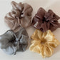 Soft pink scrunchie displayed on a white surface with natural lighting