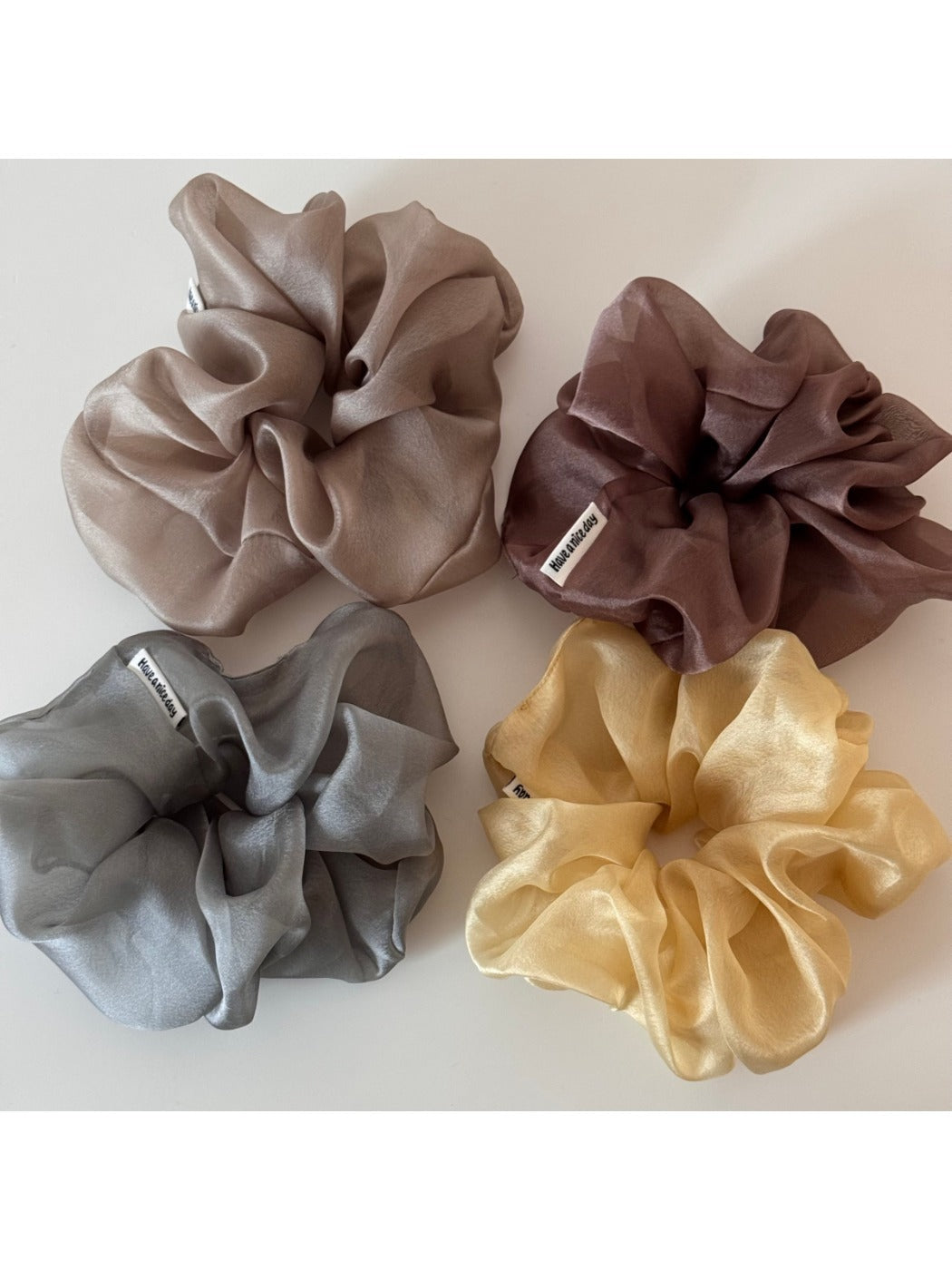 Soft pink scrunchie displayed on a white surface with natural lighting