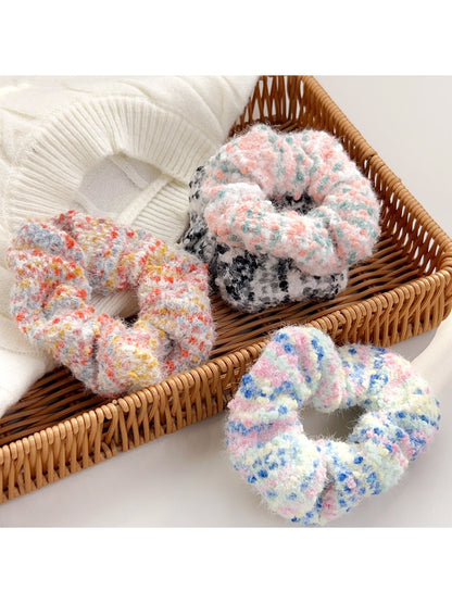 Set of three colorful headbands in pink, blue, and yellow displayed on a wooden surface