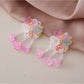 Small flower-shaped earrings displayed on a jewelry card with Earedge branding