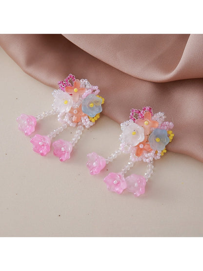 Small flower-shaped earrings displayed on a jewelry card with Earedge branding