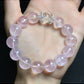 Lovra pink crystal bracelet with reflective beads against a neutral background