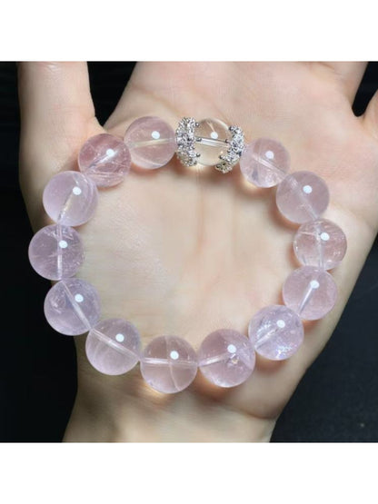 Lovra pink crystal bracelet with reflective beads against a neutral background