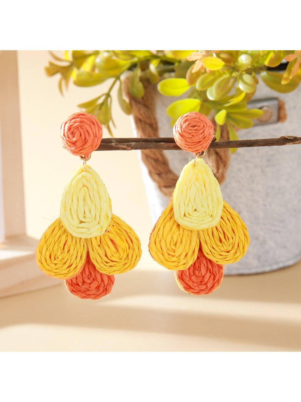 Earedge raffia drop earrings paired with matching accessories on a textured surface