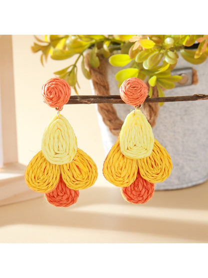 Earedge raffia drop earrings paired with matching accessories on a textured surface