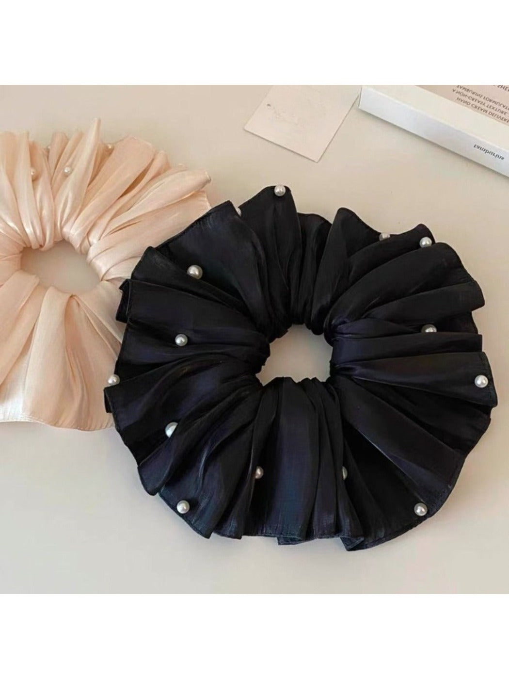 Beige satin scrunchie displayed flat showing its full size and shape